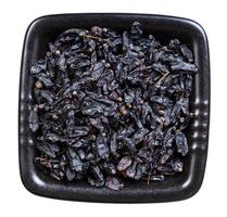 dried black barberry fruits in black bowl isolated photo