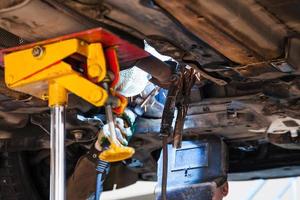 welder fixes silencer on exhaust pipe photo