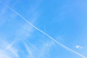 contrail and cirrus clouds in blue sky photo