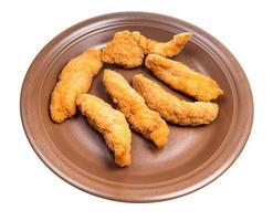 several chicken strips on brown plate isolated photo