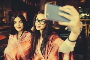 two close friends do selfie in the cafe photo