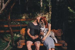 hermosa pareja junto con un perro en un columpio