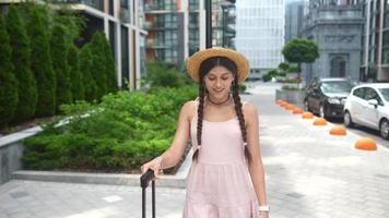 Young woman explores city while carrying luggage video