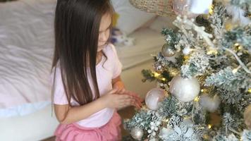 petite fille décorant le sapin de noël à la maison video