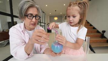 Little Girl playing with chemistry tubes at home with family video