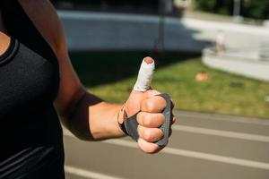 cropped view of sexy bodybuilder showing thumbs up photo