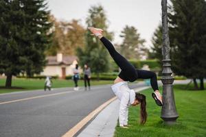 atractiva mujer flaca haciendo un backbend mientras muestra un salto mortal. foto