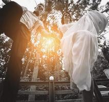 bride and groom jumping, having fun photo