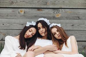 tres chicas encantadoras cerca de una casa de madera foto