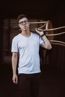 portrait of men standing with chair in white t-shirt and sunglasses in the street photo