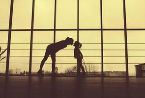 Silhouette of mother and daughter in the gym.Kiss photo