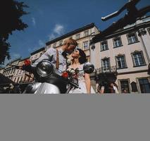 bride and groom on vintage motor scooter photo