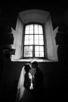 bride and groom on the background of a window. photo