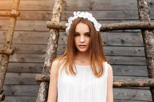 Lovely girl near a wooden house photo