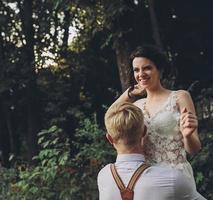 el novio sostiene a la novia en sus brazos foto