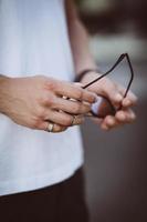 Man holds black sunglasses in hands photo