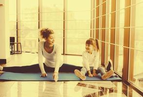 madre e hija haciendo yoga en el gimnasio foto