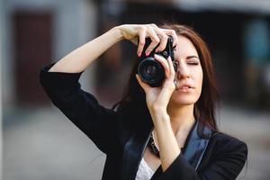 Beautiful female photographer posing with camera photo