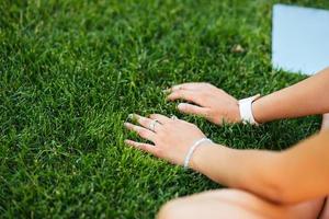 Young fit attractive woman lying on green lawn park. photo