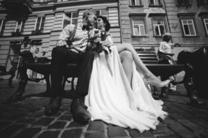 la novia y el novio se sientan en el banco foto
