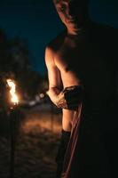 Guy with torchlight on the beach at night photo