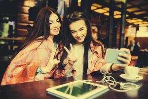 two close friends make selfie in the cafe photo