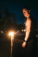 Guy with torchlight on the beach at night photo