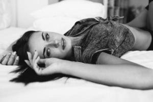 hermosa joven posando en una cama blanca foto