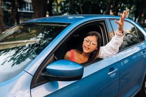 A young angry woman peeks out of the car window photo