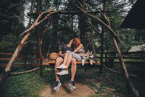 hermosa pareja junto con un perro en un columpio foto