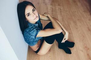 beautiful young girl posing sitting on the floor photo