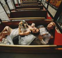 Bride and groom posing in a tour car photo