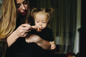 madre alimentando a su hija en casa foto