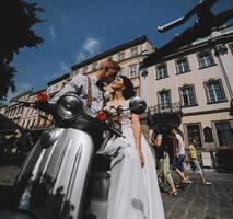 bride and groom on vintage motor scooter photo