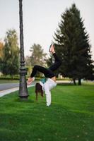 atractiva mujer flaca haciendo un backbend mientras muestra un salto mortal. foto