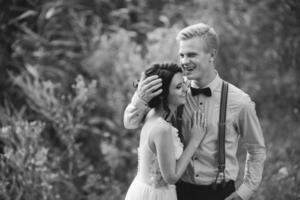 groom gently embracing his bride photo