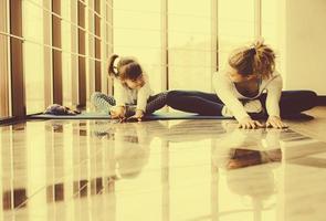 madre e hija haciendo yoga en el gimnasio foto