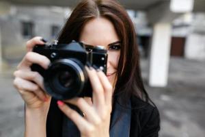 Beautiful female photographer posing with camera photo