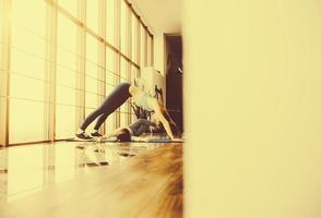 Mother and daughter stretching back in the gym photo