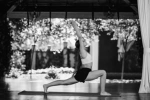 mujer joven realiza virabhadrasana. practicando yoga solo foto