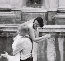 groom carries bride in his arms photo