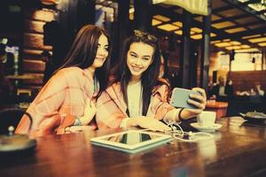 two close friends make selfie in the cafe photo