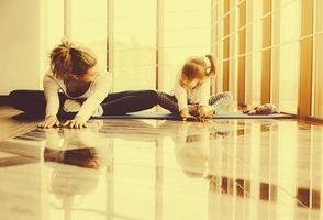 madre e hija haciendo yoga en el gimnasio foto