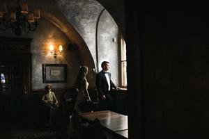 The bride and groom in a cozy house, photo taken with natural light from the window.