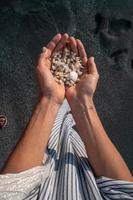 Women's hands are holding a lot of small pebbles photo