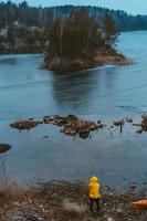 The guy is standing at the frozen lake photo