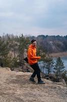 A young man standing on the edge of a cliff poses for the camera photo
