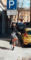 Beautiful fashionable lady posing on old street photo