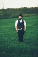 hombre con barba y gafas de sol caminando en el campo foto