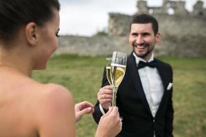 bridal couple clink glasses of champagne photo